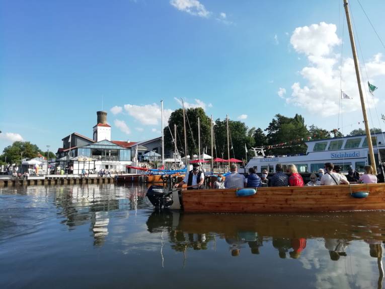 Eine Anlegestelle mit Booten davor, vom Wasser aus fotografiert